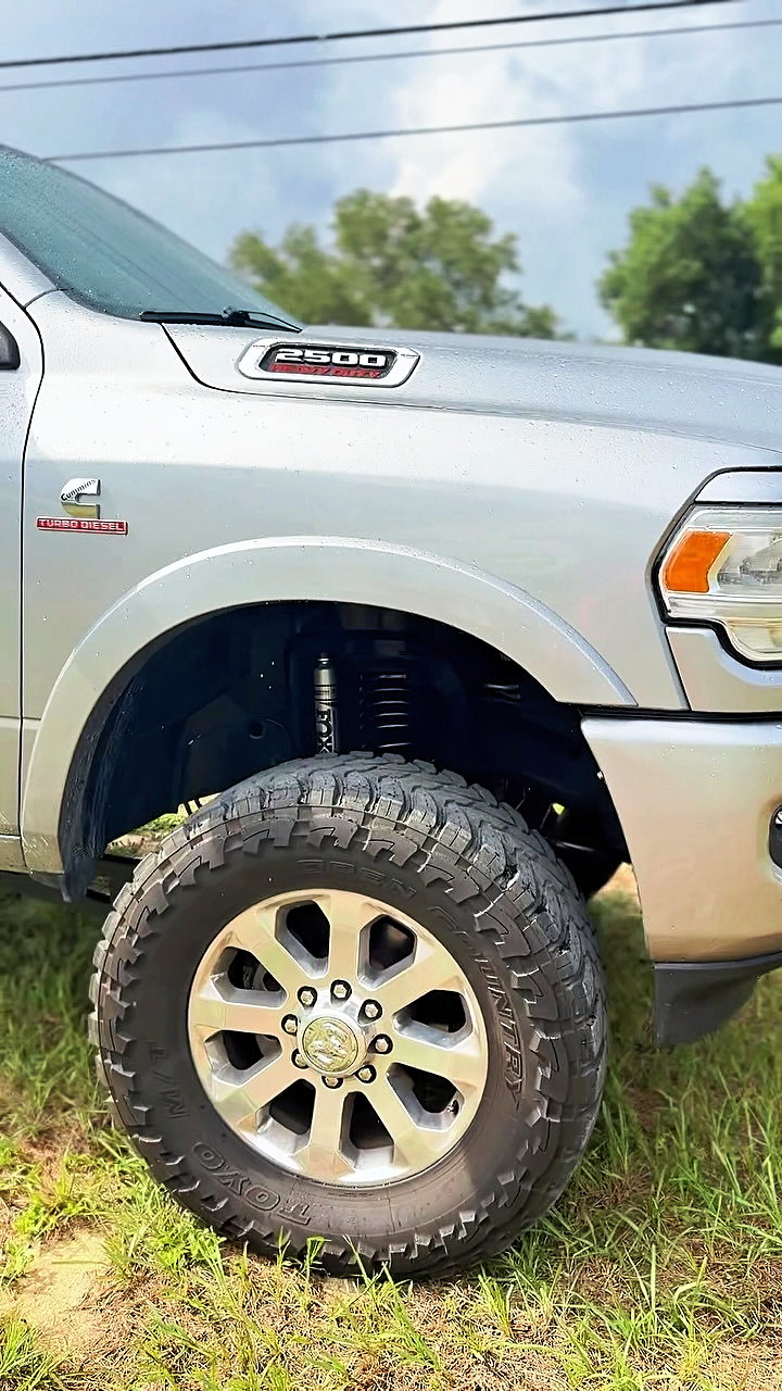 Silver RAM 2500 with a leveled front end on all-terrain tires, parked on grass (Instagram reel cover)